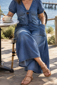Tie-front wide-leg jumpsuit in blue at a seaside cafe