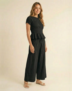 Smocked top and wide-leg pants set in black, walking