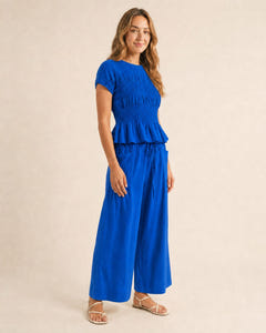 Smocked top and wide-leg pants set in blue, walking