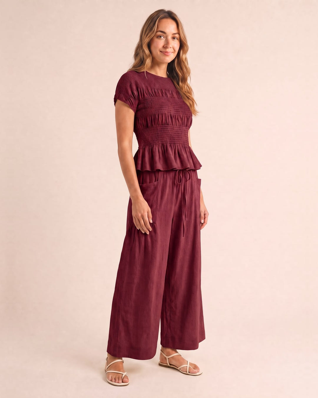 Smocked top and wide-leg pants set in burgundy, walking