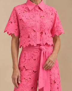 Close-up of the Coralie lace in hot pink: collar, buttons, scalloped hem and tie belt