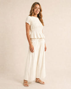 Smocked top and wide-leg pants set in cream, walking
