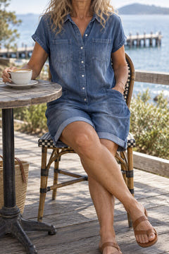 Short-sleeve denim playsuit in blue at a seaside cafe