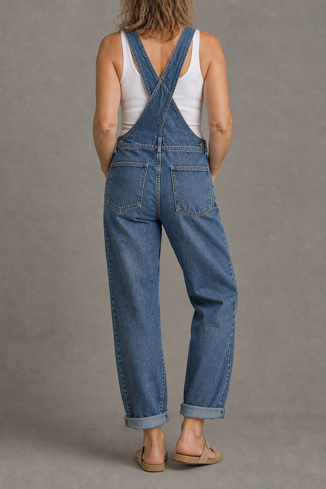 Classic denim overalls from the back, straps crossed