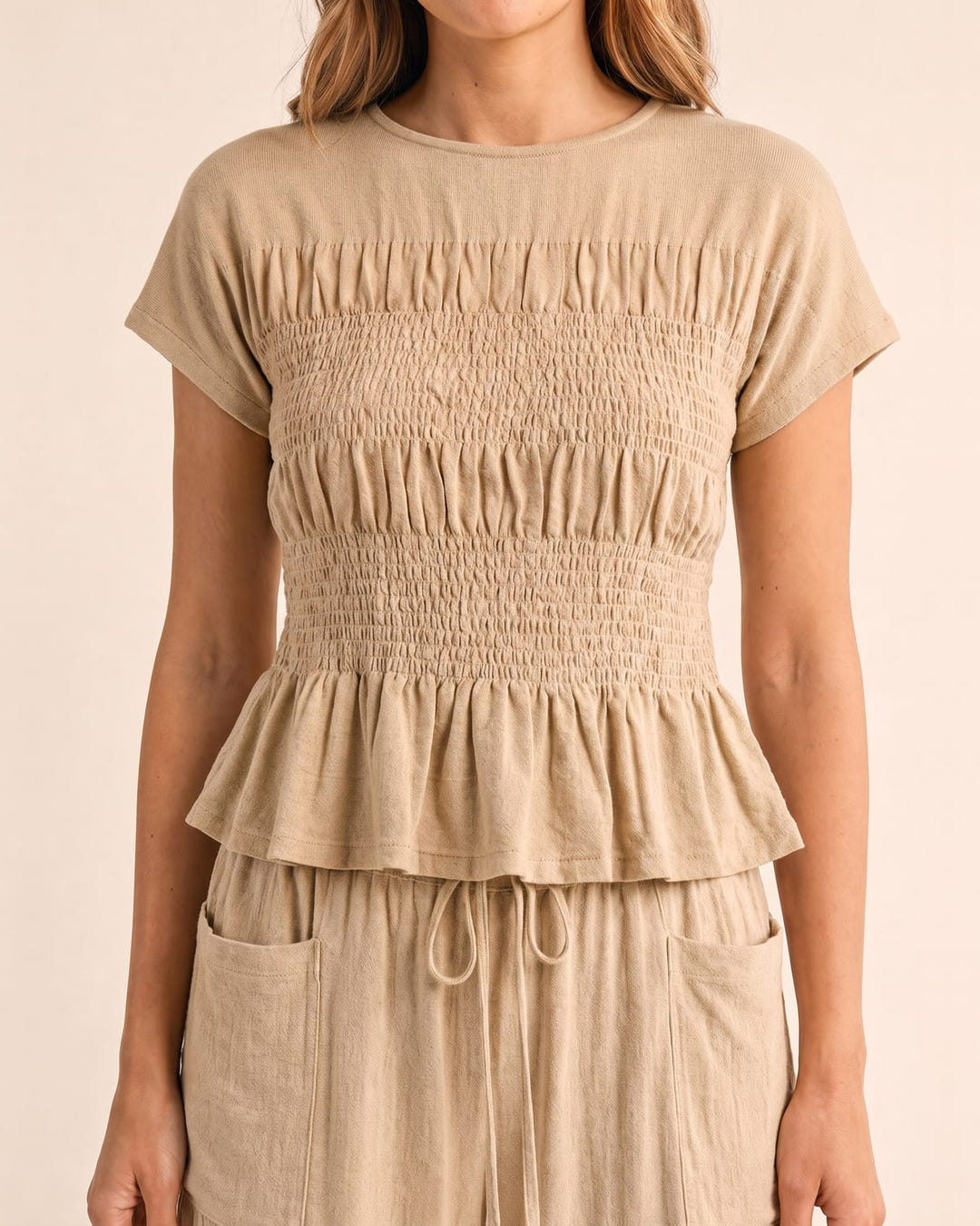 Smocked top and wide-leg pants set in sand, close-up of the smocked top