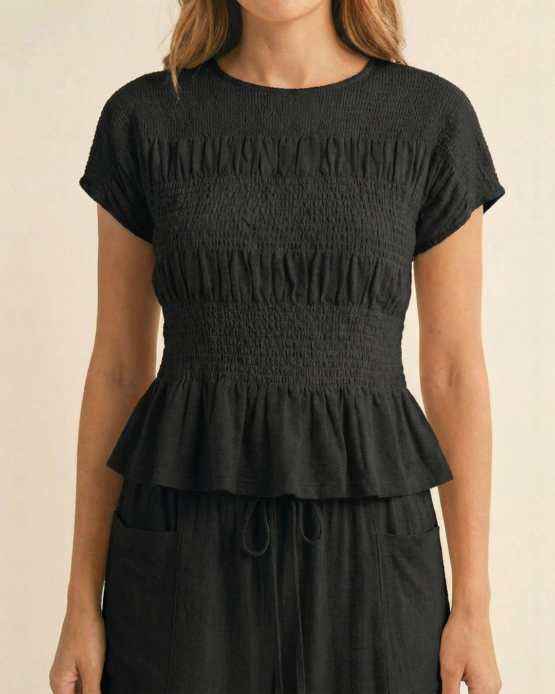 Smocked top and wide-leg pants set in black, close-up of the smocked top