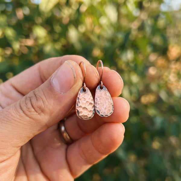 Woman wearing copper teardrop earrings