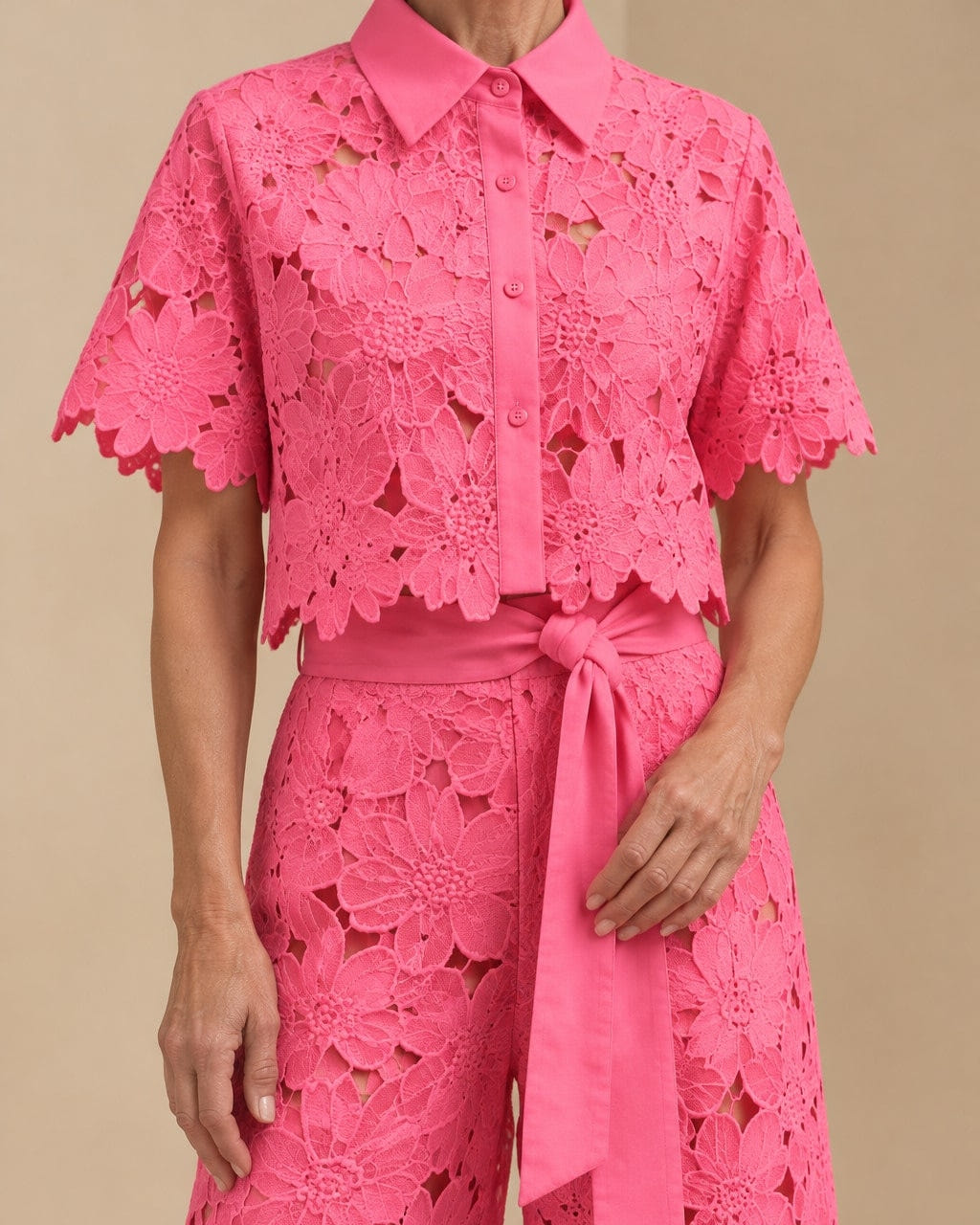 Close-up of the Coralie lace in hot pink: collar, buttons, scalloped hem and tie belt