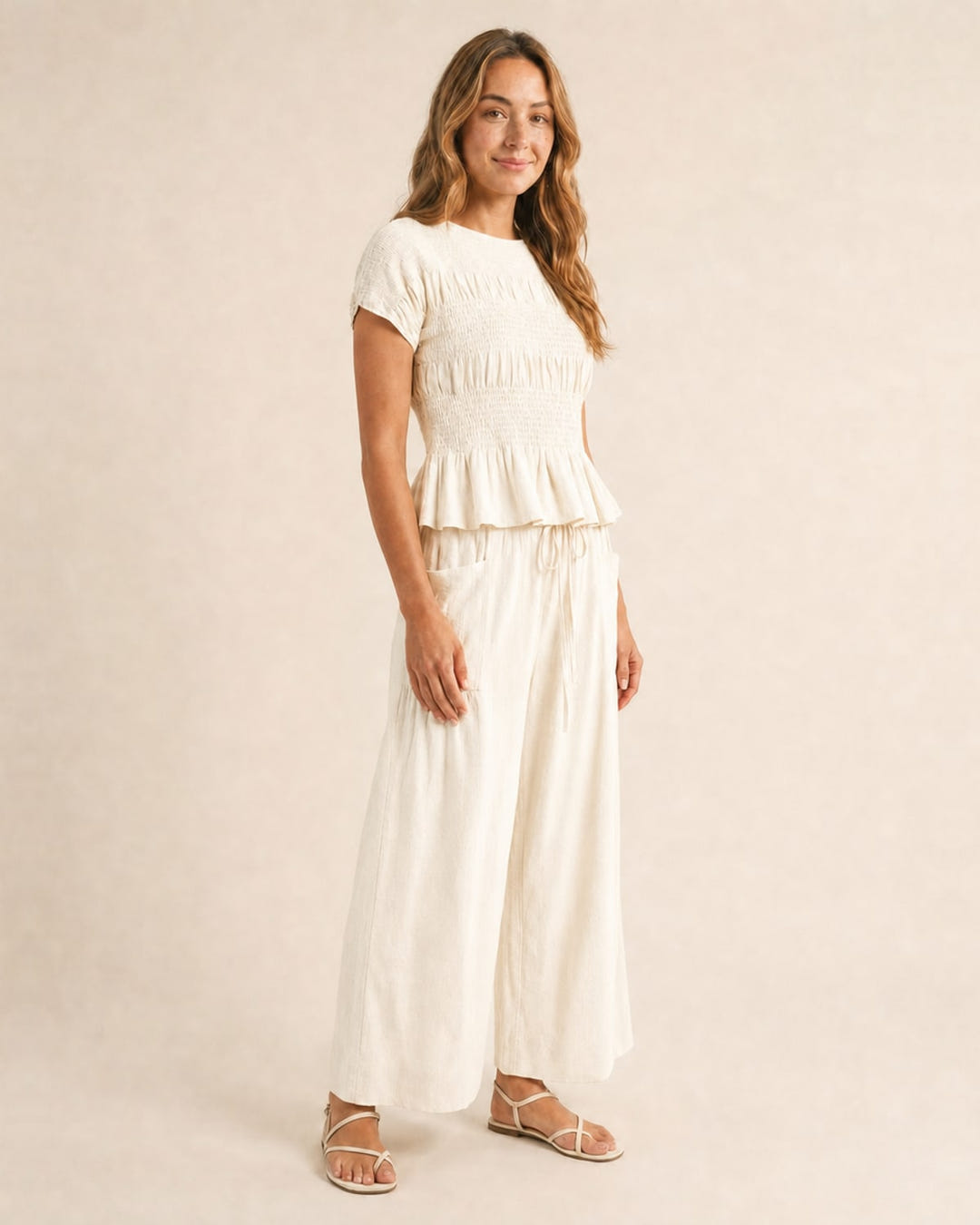 Smocked top and wide-leg pants set in cream, walking