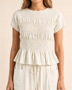 Smocked top and wide-leg pants set in cream, close-up of the smocked top