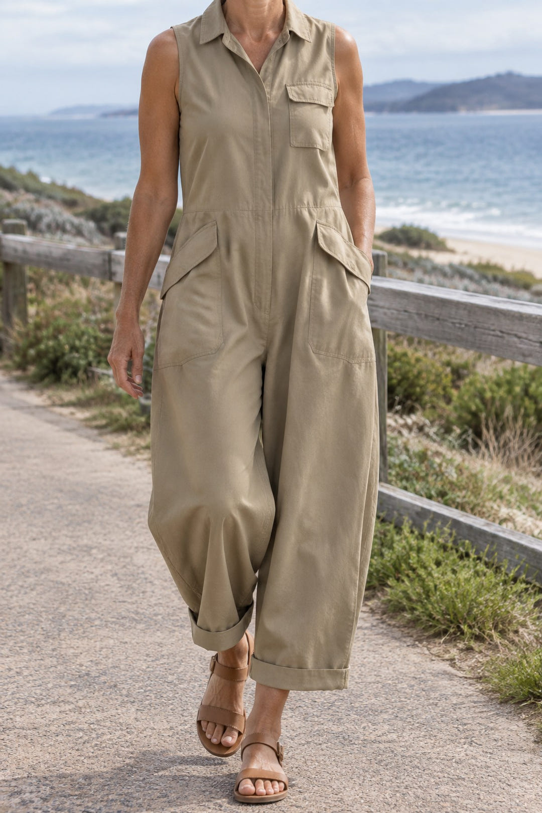 Sleeveless utility jumpsuit in khaki on a coastal walk