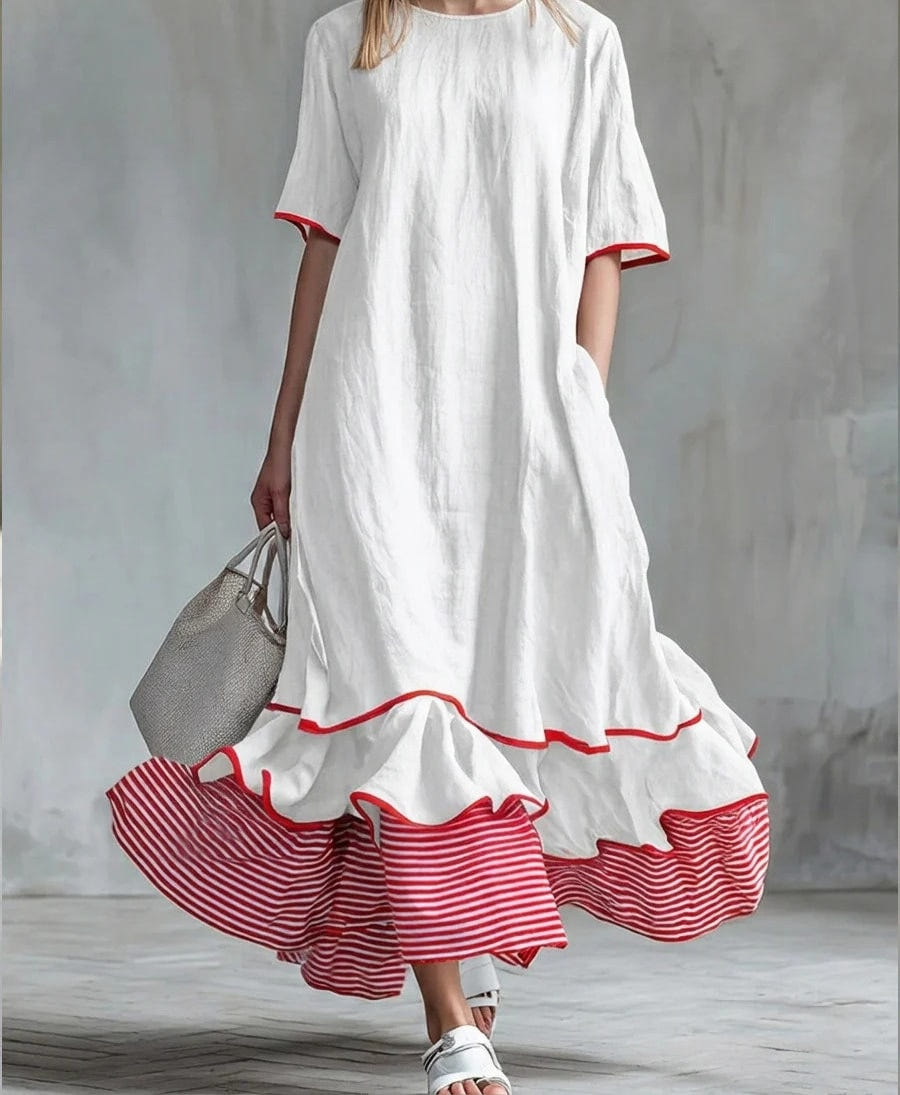 White maxi dress with red edged sleeves and a striped ruffle hem