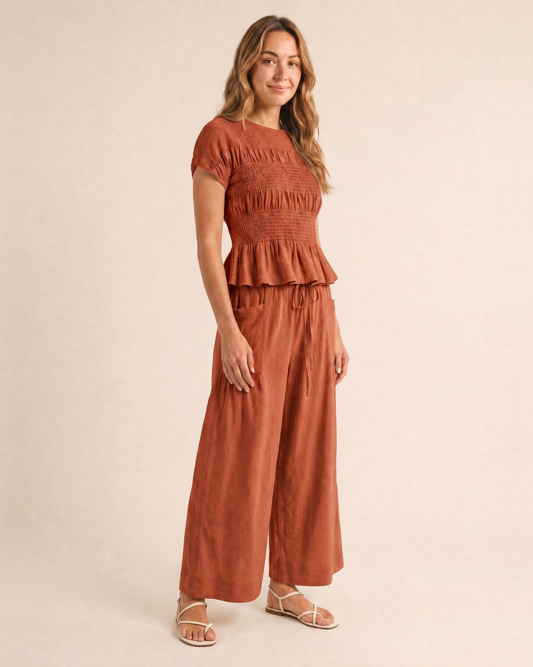 Smocked top and wide-leg pants set in rust, walking