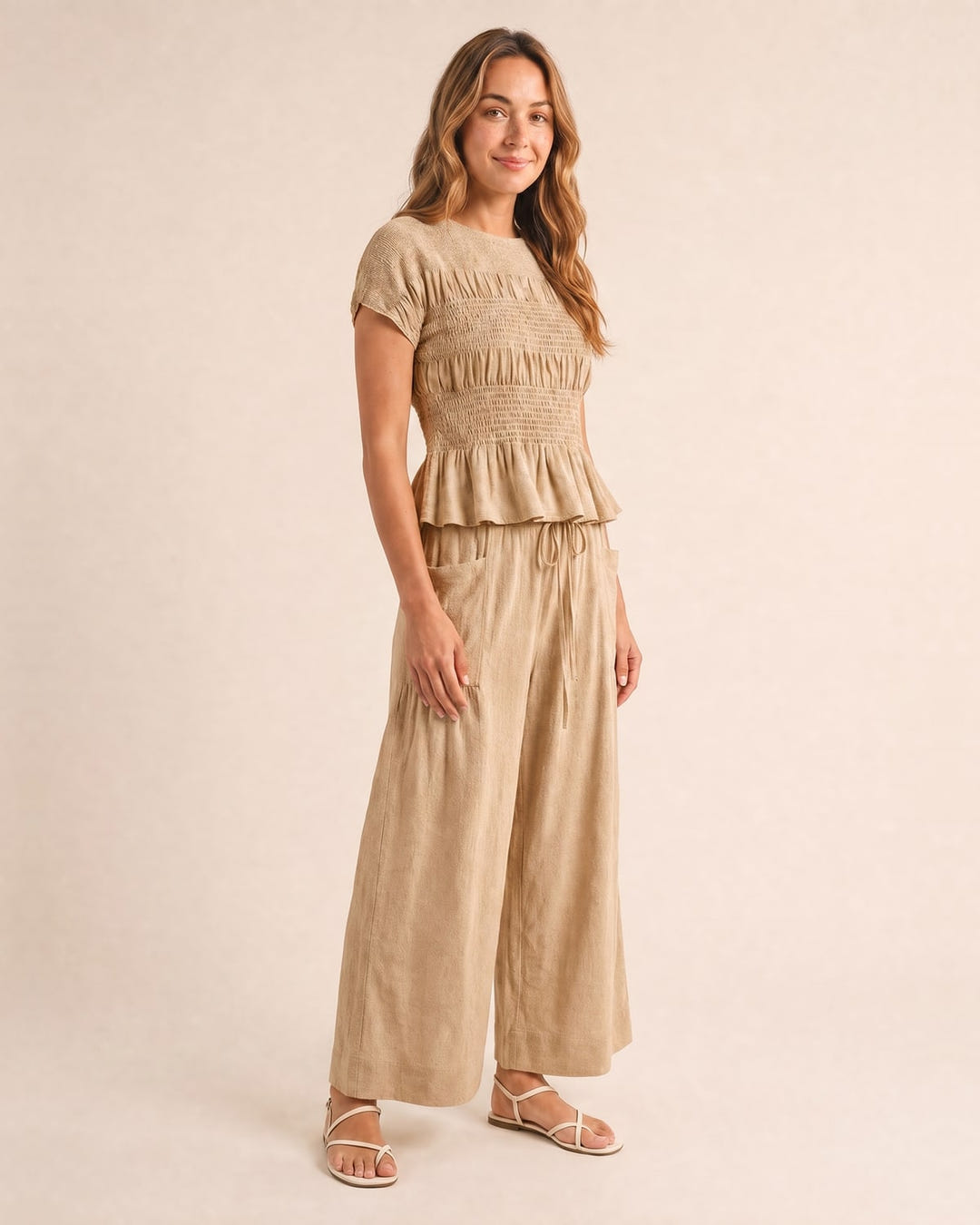 Smocked top and wide-leg pants set in sand, walking